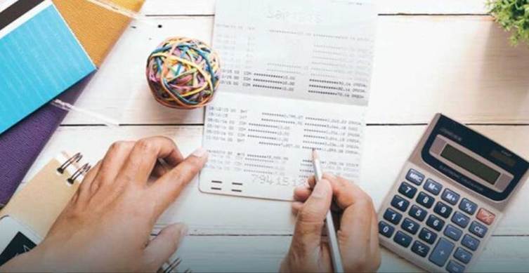 This may contain: a person is doing something on top of a desk with calculator, pencils and papers